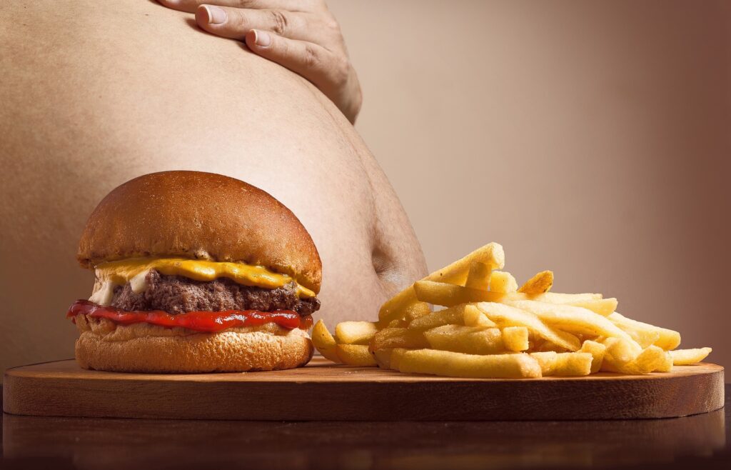 Body fat calculator image showing belly and unhealthy food